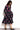 Model wears Logan black dress with pink and green spaced floral print dress. Dress has pink embroidered tapes around the front chest.