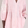 Model wears East Simran pink stripe pintuck embroidered blouse. 