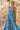 Model wears East Fleur Blue Spot Dress on the beach