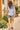 Back full length view of model walking down the street wearing East Taryn Top