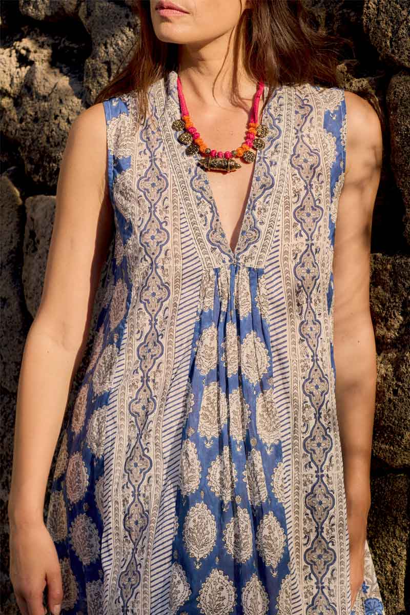 Close up of model standing against some rocks, wearing East Azul Sleeveless Dress