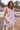 Model stands on the beach with hands in pockets wearing East Heritage Gigi White Cotton Frill Sleeve Top