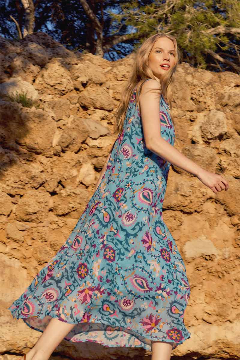 Side view of model on a rocky path wearing East Vendella Sleeveless Dress