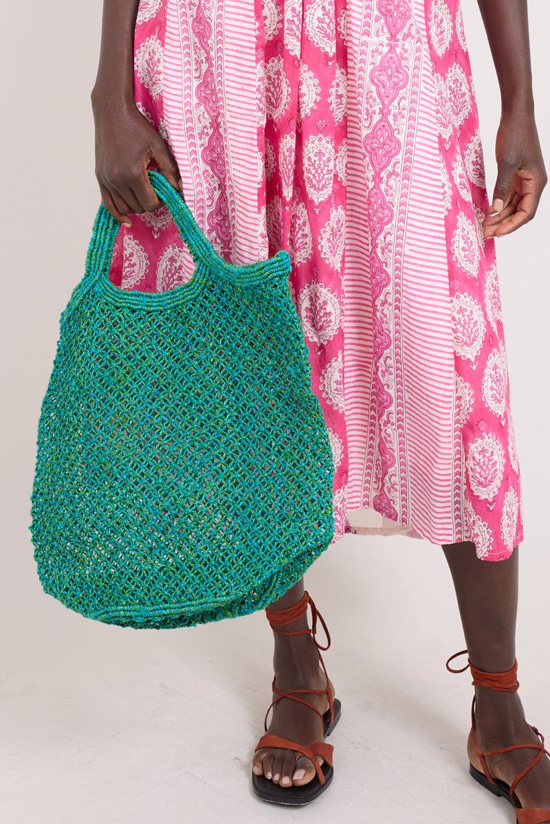 Model holds Teal Green Jute Bag